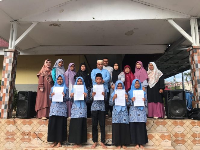 
					Kemad H. Jasrul menyerahkan rapor AKMI kepada perwakilan kelas 8 MTsN 3 Solok Selatan